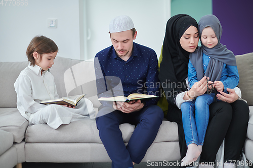 Image of Young muslim family reading Quran during Ramadan