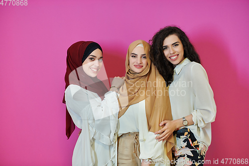 Image of Young muslim women posing on pink background