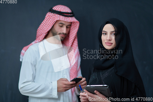 Image of Young muslim business couple using technology devices