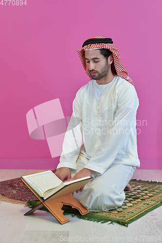 Image of Young muslim man reading Quran during Ramadan