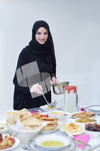 Image of Young muslim woman serving food for iftar during Ramadan