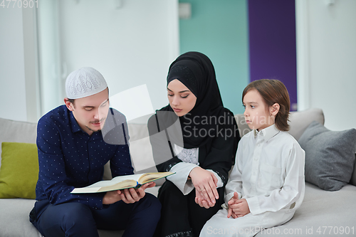 Image of Young muslim family reading Quran during Ramadan