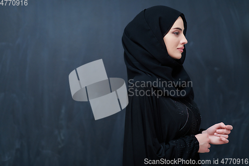 Image of Modern young muslim woman in black abaya