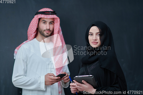 Image of Young muslim business couple using technology devices