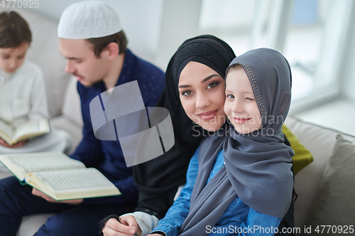 Image of Young muslim family reading Quran during Ramadan