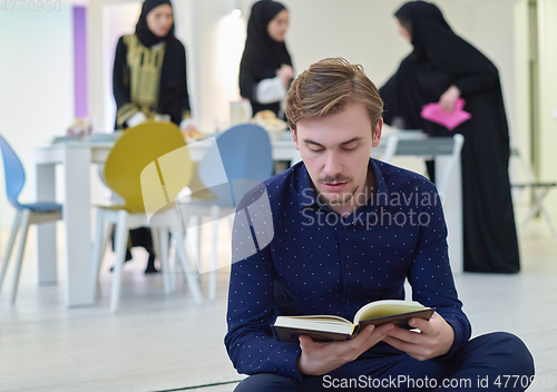 Image of Young muslim man reading Quran during Ramadan