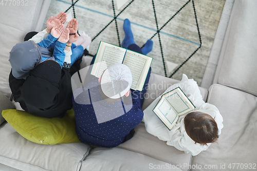 Image of Top view of young muslim family reading Quran during Ramadan