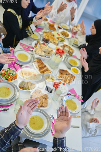 Image of Muslim family making iftar dua to break fasting during Ramadan