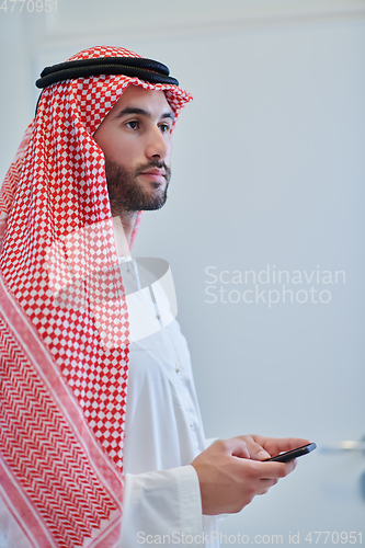 Image of Portrait of young muslim businessman using mobile phone