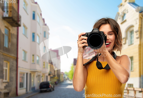 Image of happy woman photographer with camera in city