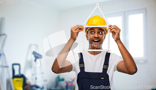 Image of happy indian builder with ruler in shape of home