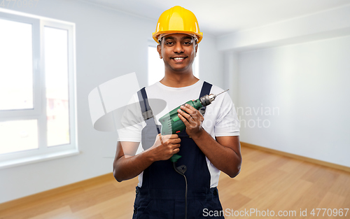 Image of happy indian builder in helmet with electric drill