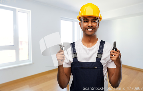 Image of indian builder in helmet with wrench and pliers