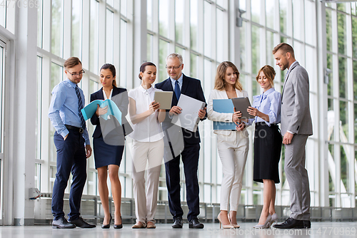 Image of business team with tablet pc and folders at office