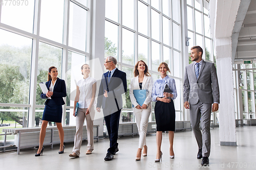 Image of business people walking along office building