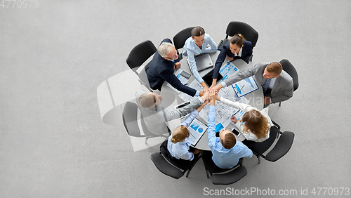 Image of happy business people stacking hands