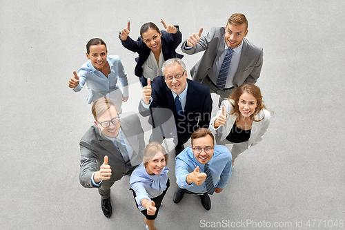 Image of happy smiling business people showing thumbs up