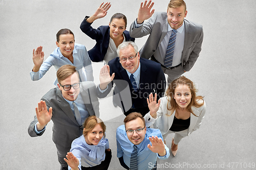 Image of happy smiling business people waving hands