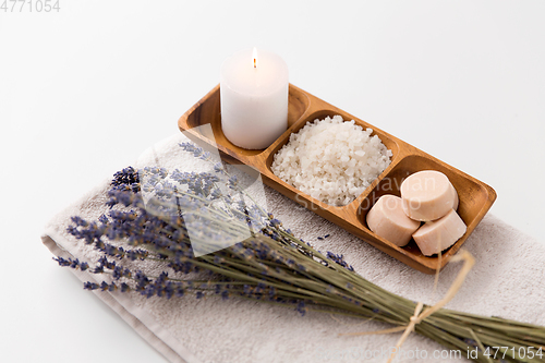 Image of sea salt, soap, candle and lavender on bath towel