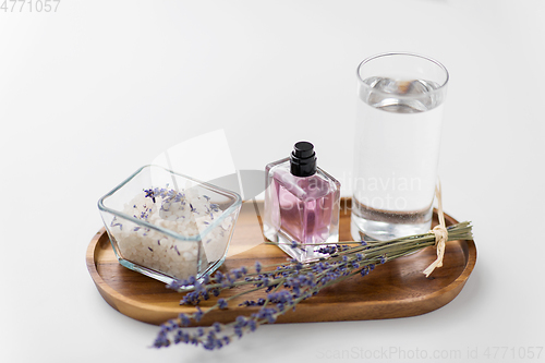 Image of sea salt, perfume and lavender on wooden tray