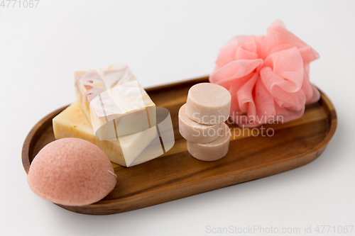 Image of crafted soap, sponge and wisp on wooden tray