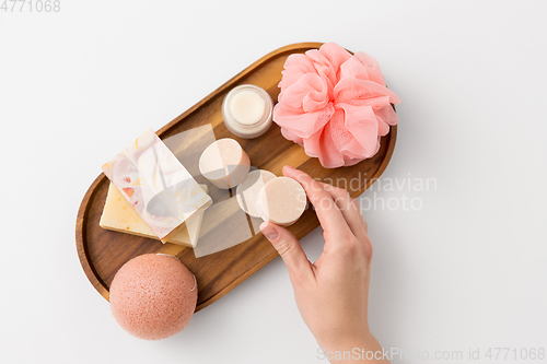 Image of hand with soap, sponge, moisturizer and wisp