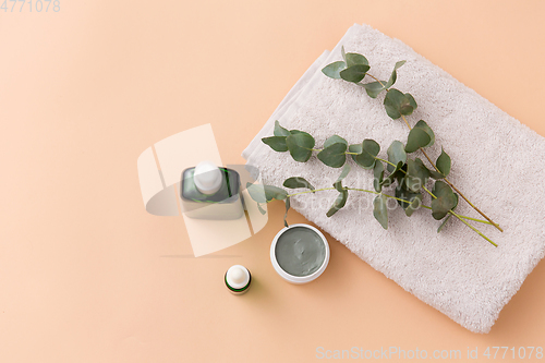 Image of serum, clay mask, oil and eucalyptus on bath towel