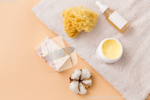 Image of body butter, essential oil, sponge on bath towel