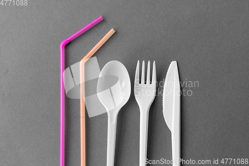 Image of disposable plastic fork, knife, spoon and straws