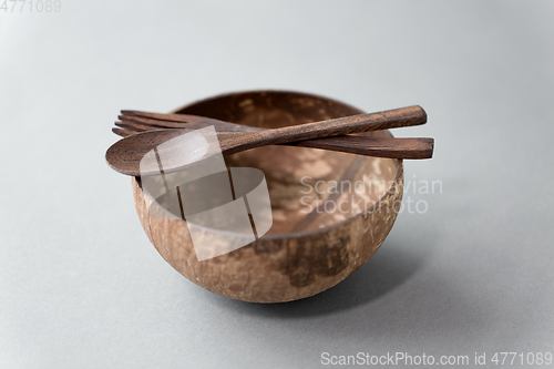 Image of close up of coconut bowl, wooden spoon and fork