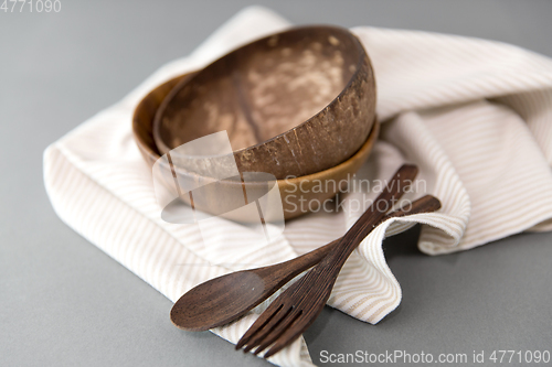 Image of close up of coconut bowl, wooden spoon and fork