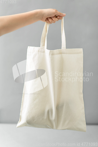 Image of hand holding reusable canvas bag for food shopping