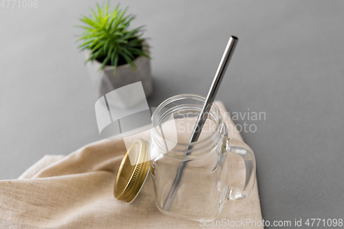 Image of empty glass mug of with reusable metallic straw