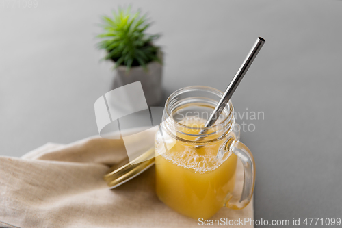 Image of glass mug of juice and reusable metallic straw