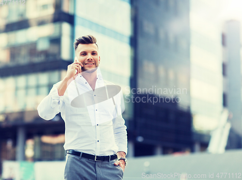 Image of happy man with smartphone calling on city street