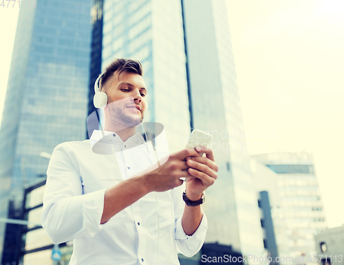 Image of man with headphones and smartphone listening music