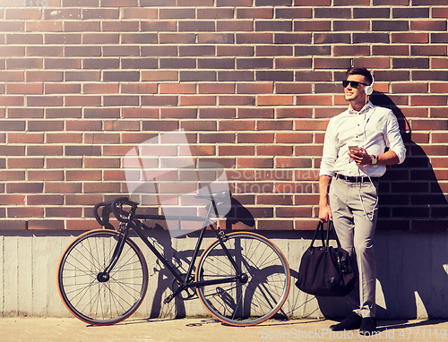 Image of man with headphones, smartphone and bicycle