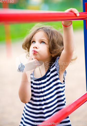 Image of Cute little girl is playing in playground