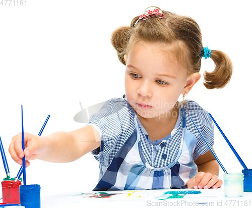 Image of Little girl is painting with gouache