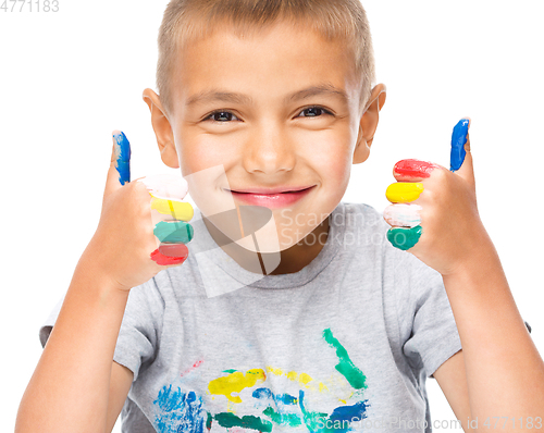 Image of Portrait of a cute boy playing with paints