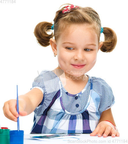 Image of Little girl is painting with gouache