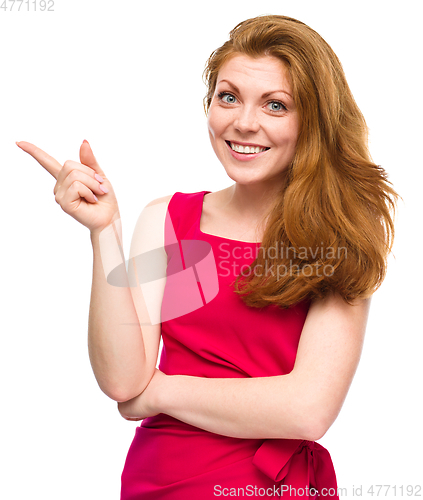 Image of Portrait of a young woman pointing to the left
