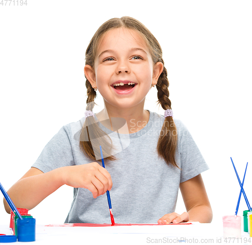 Image of Little girl is painting with gouache