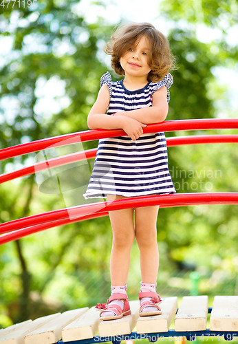 Image of Cute little girl is playing in playground