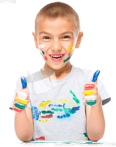 Image of Portrait of a cute boy playing with paints