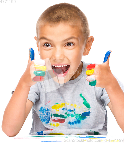 Image of Portrait of a cute boy playing with paints