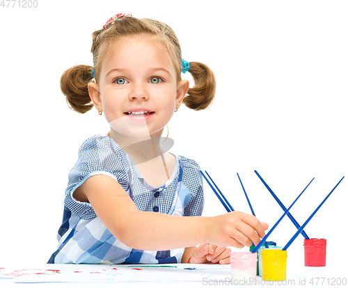 Image of Little girl is painting with gouache