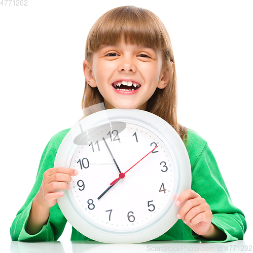 Image of Little girl is holding big clock