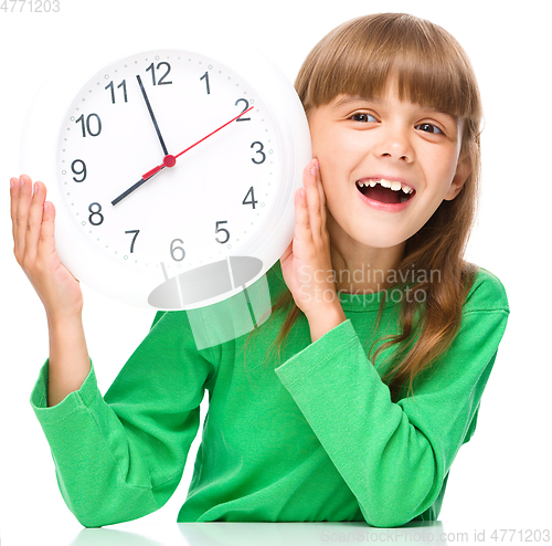 Image of Little girl is holding big clock