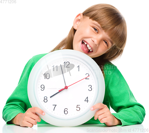 Image of Little girl is holding big clock